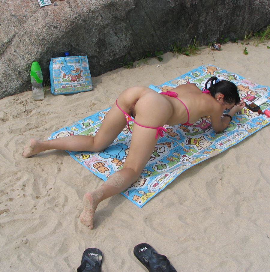 Ung kvinna i bikini visar fittan, brösten och rumpan